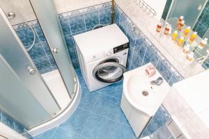 a bathroom with a washing machine and a sink at AL-DOM Apartamenty Apartament IZI in Kołobrzeg