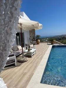 a villa with a swimming pool and an umbrella at Villa Aspria in Rethymno