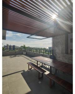 un patio avec deux bancs et une table sur le toit dans l'établissement Apartamento em Intermares a 100 metros do mar, à Cabedelo