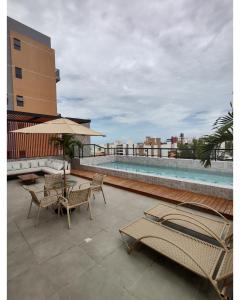 un patio con mesa, sillas y piscina en Apartamento em Intermares a 100 metros do mar en Cabedelo