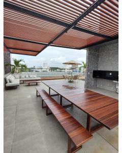 a patio with a wooden table and benches at Apartamento em Intermares a 100 metros do mar in Cabedelo