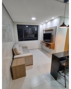 a living room with a couch and a television at Apartamento em Intermares a 100 metros do mar in Cabedelo