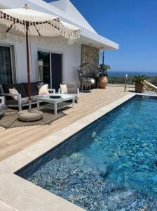 a house with a swimming pool and an umbrella at Villa Aspria in Rethymno +18 photos
