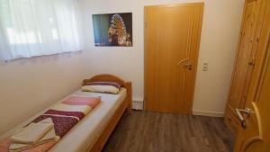 ピルナにあるFerienwohnung Richterの小さなベッドルーム(ベッド1台、ドア付)