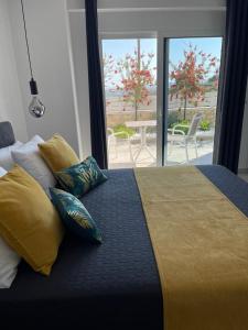 a bedroom with a bed with yellow and blue pillows at Villa Aspria in Rethymno