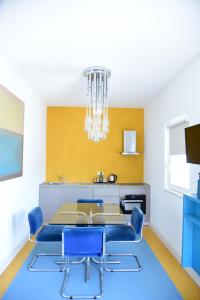 a dining room with a table and blue chairs at HMO Glamping & Suites in Vignanotica in Mattinata