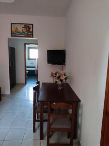 a dining room table with a vase of flowers on it at Ekaterini Apartments in Gouvia