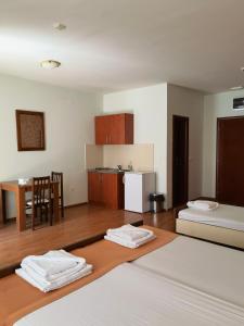 Habitación con 2 camas y cocina con mesa. en Residence Bella, en Budva
