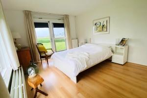 um quarto com uma cama branca e uma janela em Lakeview langweer em Langweer