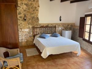 a bedroom with a bed and a stone wall at Agroturismo Finca Dalt Murada in Binissalem