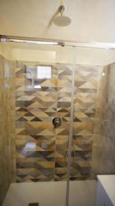 een douche met een glazen deur in de badkamer bij La Dimora nel Borgo in Ghiffa