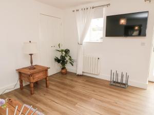 a living room with a table and a television on a wall at Humbleton in Wooler