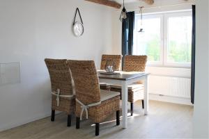 - une salle à manger avec une table et des chaises en osier dans l'établissement Elske´s Stuuv, à Krummhörn
