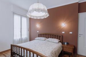 sypialnia z łóżkiem i żyrandolem w obiekcie Appartamento Picche w mieście Peveragno