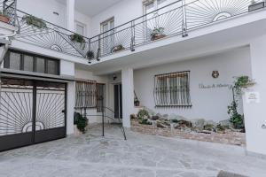 biały budynek z drzwiami i balkonem w obiekcie Appartamento Picche w mieście Peveragno