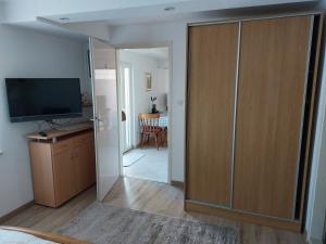 a room with a large wooden closet with a television at Apartman MARKO in Mali Lošinj