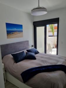 a bedroom with a large bed with blue pillows at Luxe nieuwbouw appartement op 50m van de zee in San Javier +27 photos