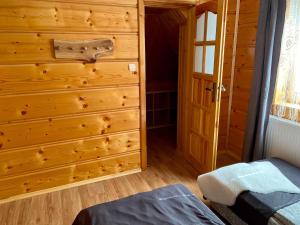 ニエジツァ・ザメクにあるApartament ASKEYの木製の壁とドアが備わるベッドルーム1室