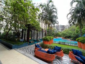 a resort with a pool and some chairs and trees at La Habana Huahin by Ying in Hua Hin