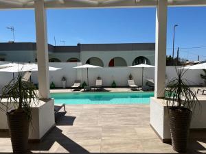 una piscina con due piante in vaso su un patio di Elite Luxury Residence a Torre Suda