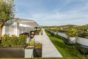 un patio al aire libre con macetas y sillas en Apartamentos Martalia Arenal, en Ronda