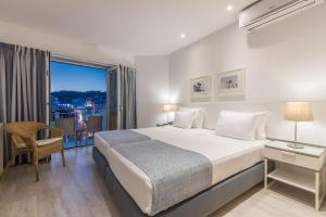 a bedroom with a bed and a large window at Hotel Baltum in Albufeira