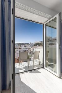 a balcony with sliding glass doors and a table and chairs at Hotel Baltum in Albufeira