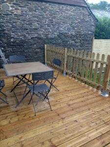 a patio with a table and chairs on a wooden deck at Picturesque holiday cottage Britanny France in Treuscoat