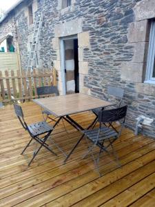 a wooden table and two chairs on a wooden deck at Picturesque holiday cottage Britanny France in Treuscoat