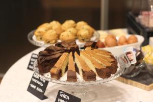 a chocolate cake on a table with other desserts at Hotel Cavour in Novara