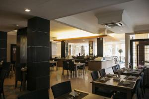 jadalnia ze stołami i krzesłami w restauracji w obiekcie Comforta Hotel Tanjung Pinang w mieście Tanjungpinang