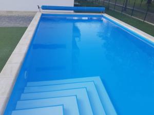 duży basen z niebieską farbą w obiekcie Sunset Beach Apartment direkt am Strand mit Pool Garten Terasse viel Komfort w Siófoku