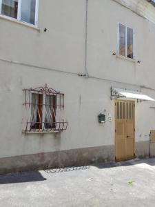 ein Gebäude mit einem vergitterten Fenster und einer Tür in der Unterkunft Casa vacanze a Furci (Chieti) in Furci