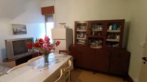 ein Wohnzimmer mit einem Tisch und einer Blumenvase in der Unterkunft Casa vacanze a Furci (Chieti) in Furci