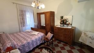 1 dormitorio con cama, tocador y espejo en Casa vacanze a Furci (Chieti), en Furci