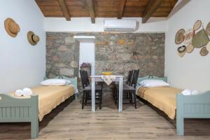 a room with two beds and a table at Ρίζες - Rizes in Repanídhion