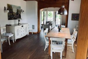 - une salle à manger et un salon avec une table et des chaises dans l'établissement Landhaus am Achterwasser mit Bootssteg, à Grüssow