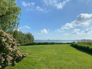 un campo de hierba con vistas al agua en Lakeview langweer, en Langweer