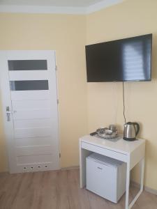 a room with a white table with a tv on a wall at Pokoje Gościnne Wiki & Ola in Mrzeżyno
