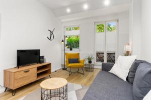 a living room with a couch and a tv at City-Apartment direkt in den Parkanlagen in Bremen