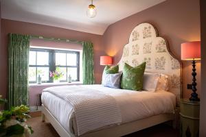 a bedroom with a bed with a headboard and a window at The White Lion Cowbridge in Cowbridge
