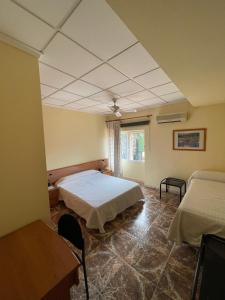 um quarto com 2 camas e uma janela em Hostal Rosaleda em Alcalà de Xivert