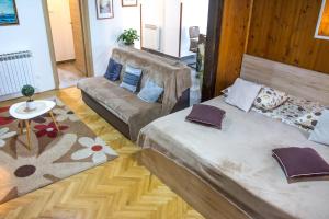 - un salon avec deux lits et un canapé dans l'établissement Apartman Joso, à Sukošan