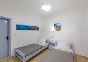 a bedroom with two beds and a window at SantoriniNY in Perissa