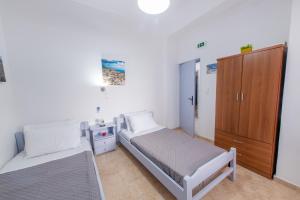a bedroom with a bed and a wooden cabinet at SantoriniNY in Perissa