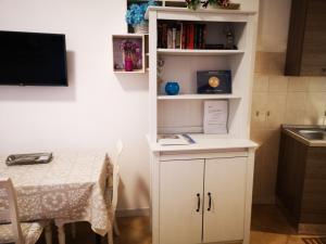 a small kitchen with a table and a white book shelf at Alfieri home holiday in Rome