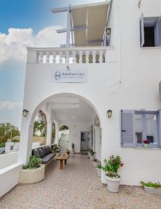 a building with an archway with a couch and a table at SantoriniNY in Perissa