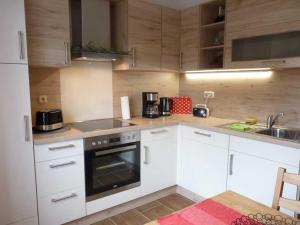 a kitchen with white cabinets and a stove top oven at Ferienwohnung "Christine" Objekt ID12096-8 in Waren