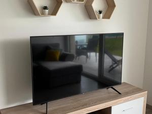 duży telewizor z płaskim ekranem siedzący na stole w obiekcie Sunset Beach Apartment direkt am Strand mit Pool Garten Terasse viel Komfort w Siófoku