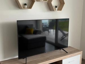 a large flat screen tv sitting on a table at Sunset Beach Apartment direkt am Strand mit Pool Garten Terasse viel Komfort in Siófok